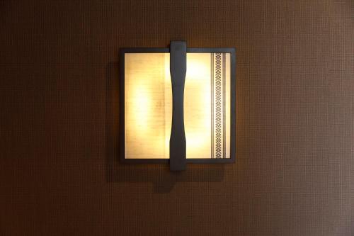 a light on a wall in a room at HOTEL Third Place Hakata in Fukuoka