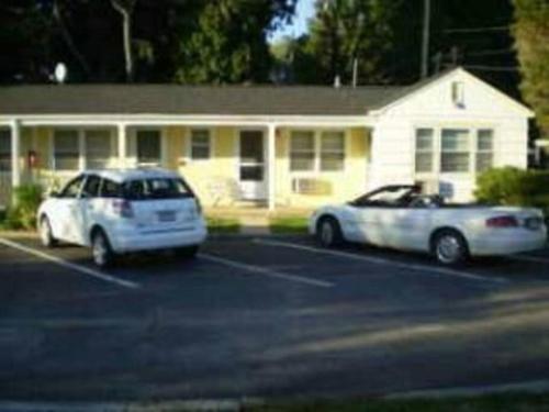 two cars parked in a parking lot in front of a house at Cozy, cute beach condo in Westerly RI . Best value in Westerly!! in Westerly