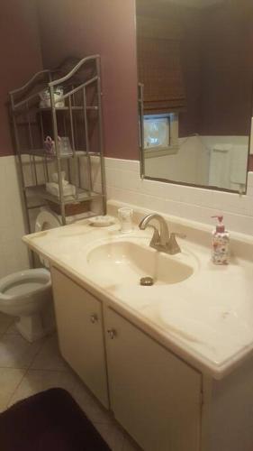 a bathroom with a sink and a toilet and a mirror at Cozy, cute beach condo in Westerly RI . Best value in Westerly!! in Westerly
