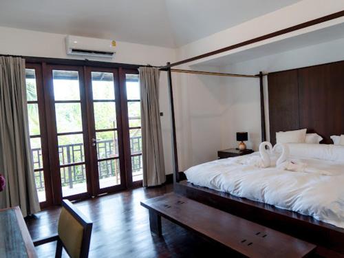 a bedroom with a large bed with a large window at 3 Bedroom Seaview Villa Haven on Beachfront Resort in Koh Samui 