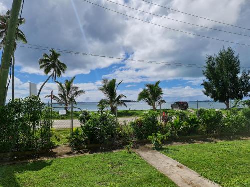 a view of the ocean from a yard with palm trees at Sky Lodge in Nuku‘alofa