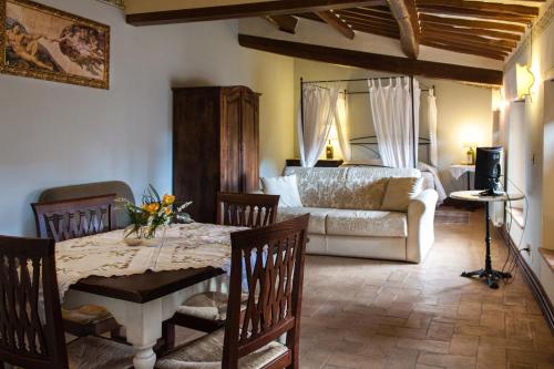 uma sala de estar com uma mesa e uma cama em Anna Camere em Montalcino