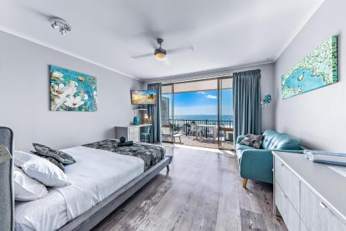 1 dormitorio con cama y vistas al océano en Ocean View 16A Studio Pool & Spa Wi-Fi en Airlie Beach