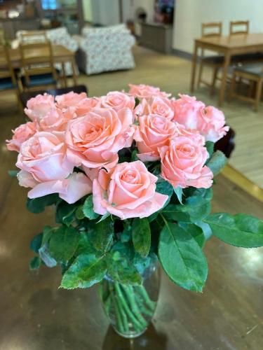a vase filled with pink roses on a table at 南庄漫晨旅店Nanzhuang Manchen B&B in Nanzhuang