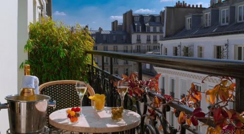 a table on a balcony with glasses of wine at B Montmartre in Paris