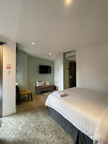 a bedroom with a large bed and a television at G1 Lodge in Baguio