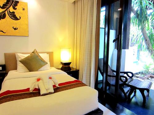 a bedroom with a bed with two stuffed animals on it at Yantarasri Resort in Chiang Mai
