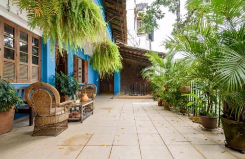 a courtyard with palm trees and a blue building at Santa Teresa Junto à Natureza in Rio de Janeiro