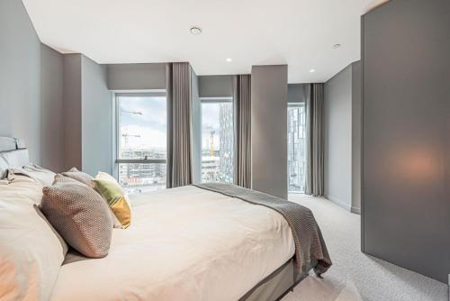 a bedroom with a large bed with a large window at The Cut- Stylish Riverside family home in London
