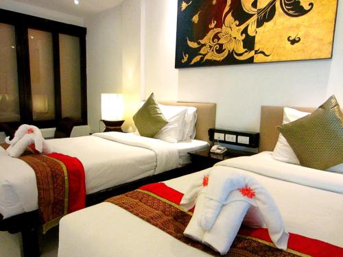 a hotel room with two beds with towels on them at Yantarasri Resort in Chiang Mai