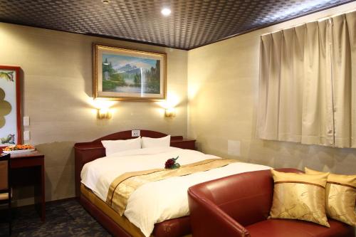 a bedroom with a large bed and a couch at Hotel DOLPHIA-Adult Only in Daisen