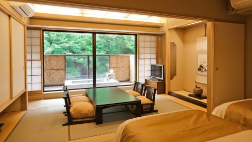 箱根町にある天成園のテーブルと椅子、窓が備わる客室です。