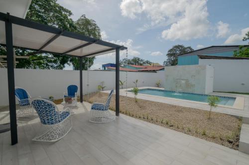 a patio with chairs and a swimming pool at Villa Golden Dream in San Felipe de Puerto Plata