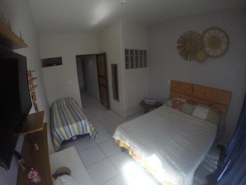 Dormitorio pequeño con cama y TV en Casas Maragogi 1, en Maragogi