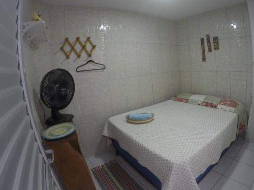 Habitación pequeña con cama y ventilador. en Casas Maragogi 2, en Maragogi