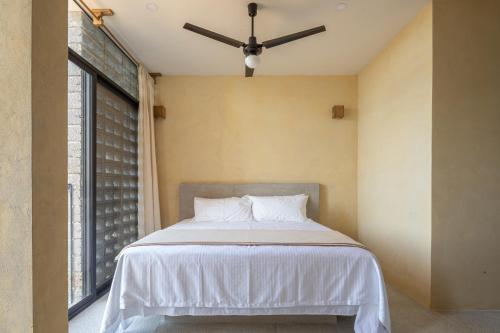 a bedroom with a bed with a ceiling fan at Casa Kame in Puerto Escondido