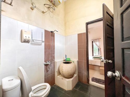 a bathroom with a toilet and a sink at Homestay Sawitsari Dekat Pakuwon Mall dan UGM by Simply Homy in Yogyakarta