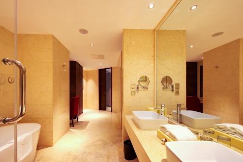 a bathroom with two sinks and a tub and a mirror at Lia Charlton Hotel Shenzhen in Shenzhen