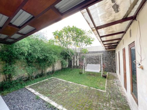 an outside view of a garden with a bench at Homestay Sawitsari Dekat Pakuwon Mall dan UGM by Simply Homy in Yogyakarta