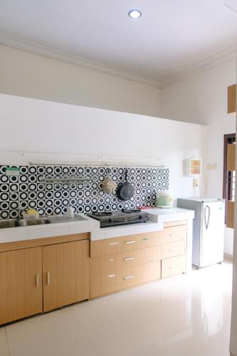 a kitchen with a black and white pattern on the wall at Homestay Sawitsari Dekat Pakuwon Mall dan UGM by Simply Homy in Yogyakarta