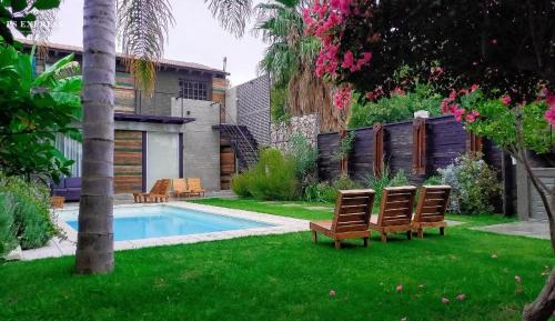 a yard with two chairs and a swimming pool at H125 - Complejo Mendoza in Mendoza