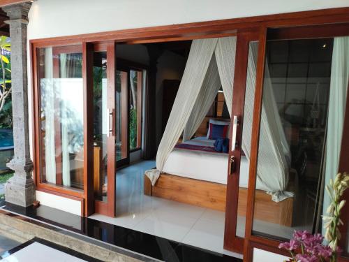 a bedroom with a hammock on a house at Baruna Sari Villa in Ubud