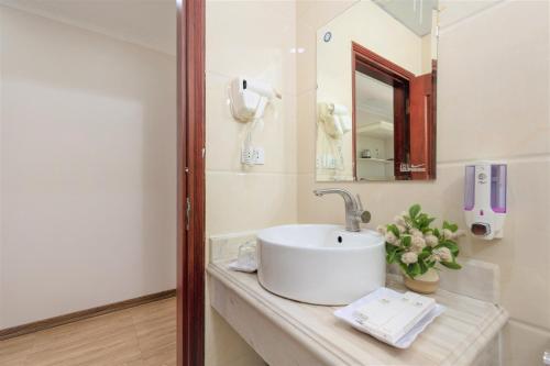 een badkamer met een wastafel en een spiegel bij Phoenix Hotel Ha Long in Ha Long