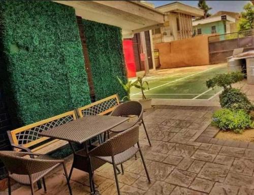 a patio with a table and chairs and a green wall at The Midpoint Residences in Mandaue City