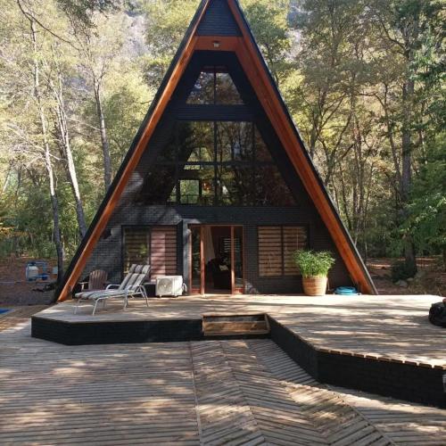 ein Haus mit einem dreieckigen Dach und einer Terrasse in der Unterkunft Deume alpina in Chillán
