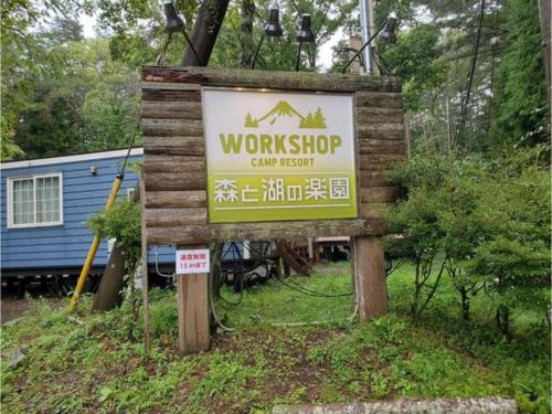 ein Schild für einen Arbeitsbereich vor einem Haus in der Unterkunft Work Shop Camp Resort Forest and Lake Paradise - Vacation STAY 85271v in Fujikawaguchiko