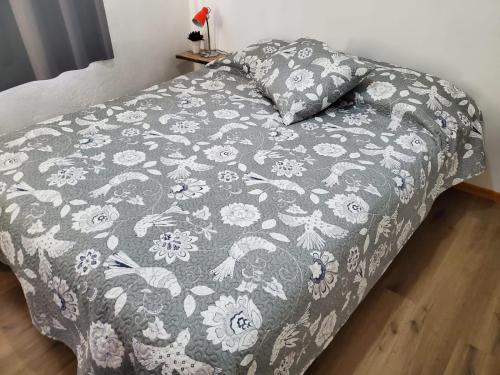 uma cama com um cobertor cinzento e branco e uma almofada em En Concordia, casa estilo industrial con amplio patio a 10 minutos de la plaza principal em Concordia