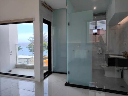 a bathroom with a glass shower and a toilet at Kenting Onehome in Checheng