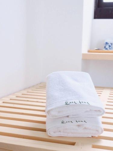 a stack of towels sitting on top of a bed at Kenting Onehome in Checheng