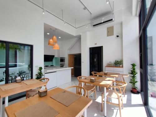a room with tables and chairs and a kitchen at Kenting Onehome in Checheng