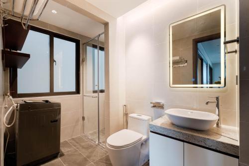 a bathroom with a toilet and a sink and a mirror at MK Riverside Apartment by Haviland in Da Nang