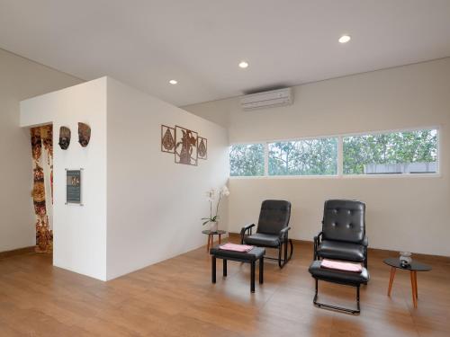 a waiting room with two chairs and a window at Hotel Santika Gunungkidul in Siyonokulon