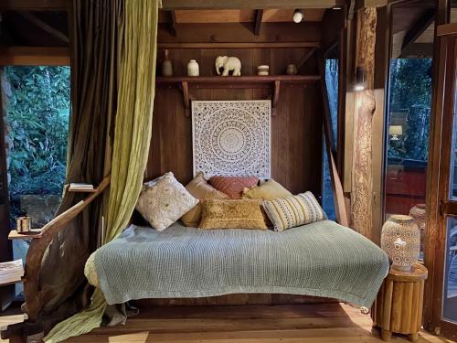 a bed with a canopy in a room at Currumbin Rainforest Treehouse in Currumbin Valley