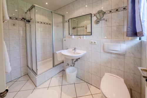 e bagno con servizi igienici, lavandino e doccia. di Gästehaus Döring a Mittenwald
