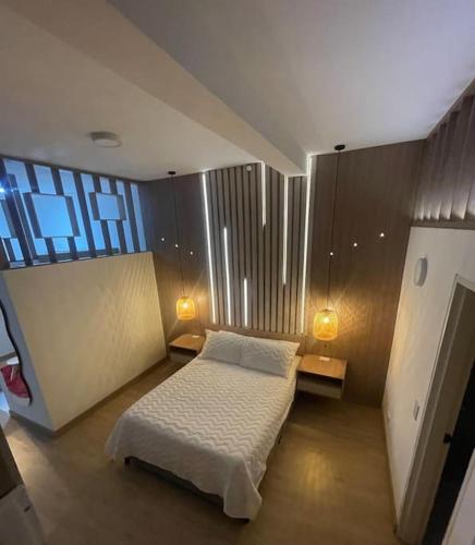 a small bedroom with a bed and two lamps at Magnifico apartaestudio in Manizales
