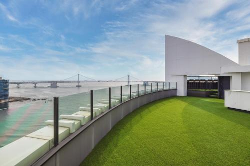 a balcony with chairs and a view of a bridge at Kent Hotel Gwangalli by Kensington in Busan