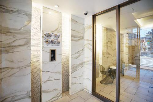 a lobby with a stone wall and a glass door at 川HOUSE黒門 in Osaka