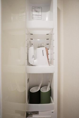 a refrigerator with a tea kettle and cups in it at 川HOUSE黒門 in Osaka