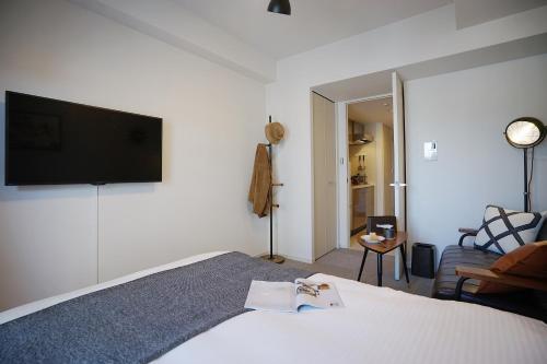 a bedroom with a bed with a television on the wall at 川HOUSE黒門 in Osaka