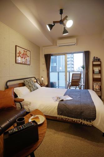 a hotel room with a bed and a couch and a window at 川HOUSE黒門 in Osaka