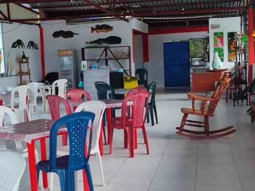 une salle à manger avec des tables et des chaises colorées dans l'établissement Hospedaje Mirador Grecia, à Leticia