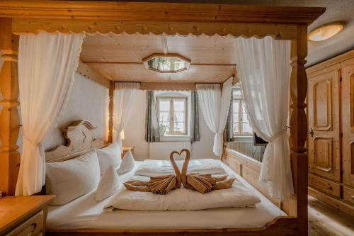 1 dormitorio con cama con dosel y cortinas blancas en Ferienhaus Bichler, en Mittenwald