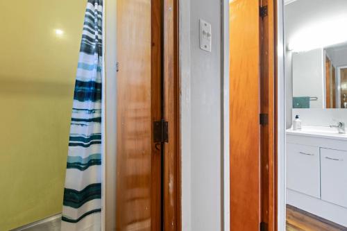a bathroom with a shower curtain and a sink at The Blue Bach - Lake Rotoiti Holiday Home in Rotoiti