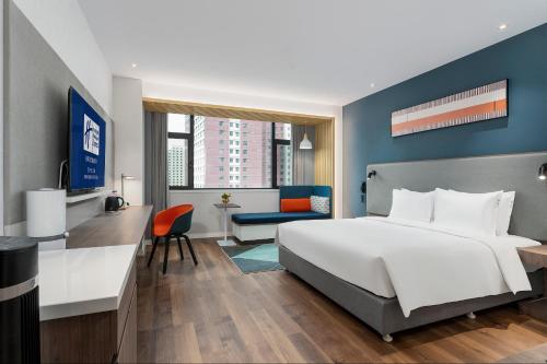 um quarto com uma grande cama branca e uma secretária em Holiday Inn Express Xining Railway Station, an IHG Hotel em Xining