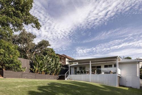 a house with a fence in front of a yard at The Aura House in Tweed Heads