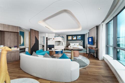 a living room with a white couch and blue chairs at Holiday Inn Express Xining Railway Station by IHG in Xining